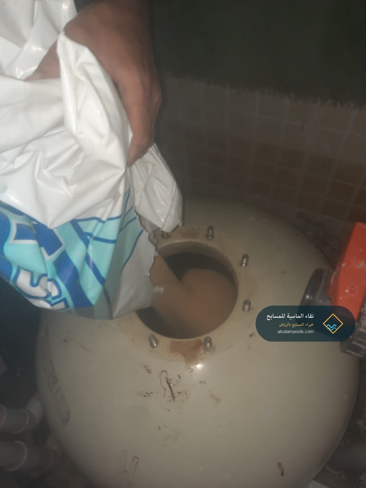 فني نقاء الماسية يصب وسط ترشيح زجاجي داخل خزان فلتر المسبح